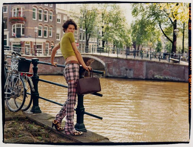 Wool sweater, Prada. Cotton pants, Area. Leather belt, Hermès. Leather bag, Miu Miu. Synthetic leather boots, Marni.