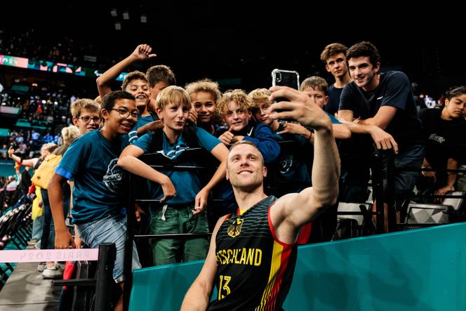 Le joueur allemand de basket-fauteuil Thomas Böhme prend un selfie avec des élèves, à Paris Bercy Arena, le 3 septembre 2024.