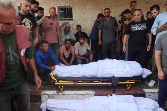 À Deir Al-Balah, une ville du centre de la bande de Gaza, des Palestiniens se tiennent devant les corps des personnes tuées à Nusseirat.