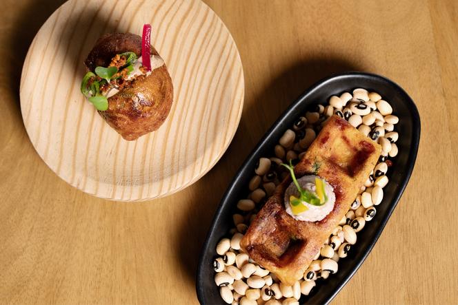 Mikate (beignet), mayonnaise à l’ail noir, épices dibi, et gaufre de manioc, houmous aux haricots niébé, réalisés par le chef Hugues Mbenda, au restaurant Kin, à Marseille, le 31 août 2024.