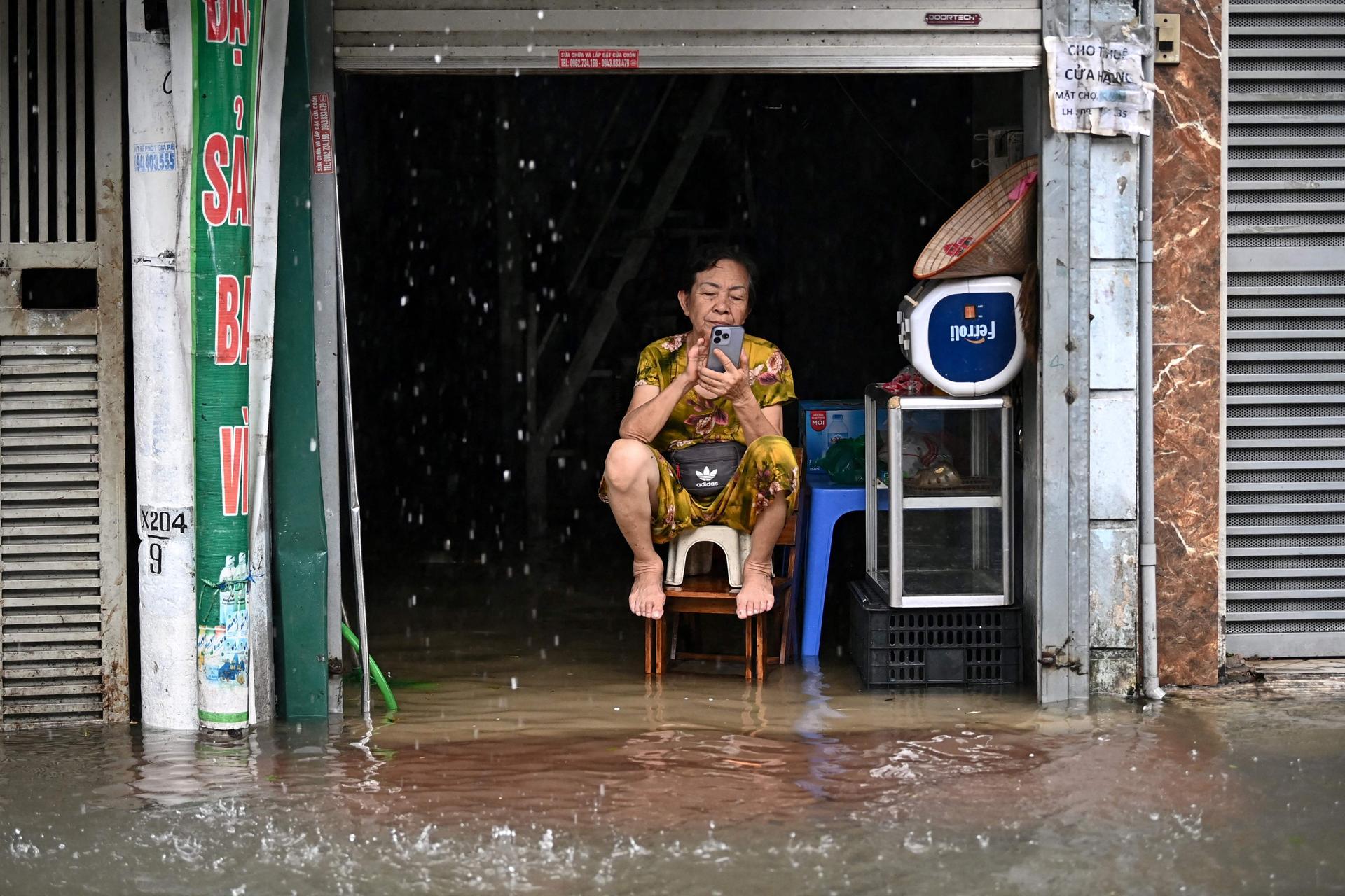 A woman sits above floodwaters in her home in Hanoi (Vietnam), September 11, 2024.