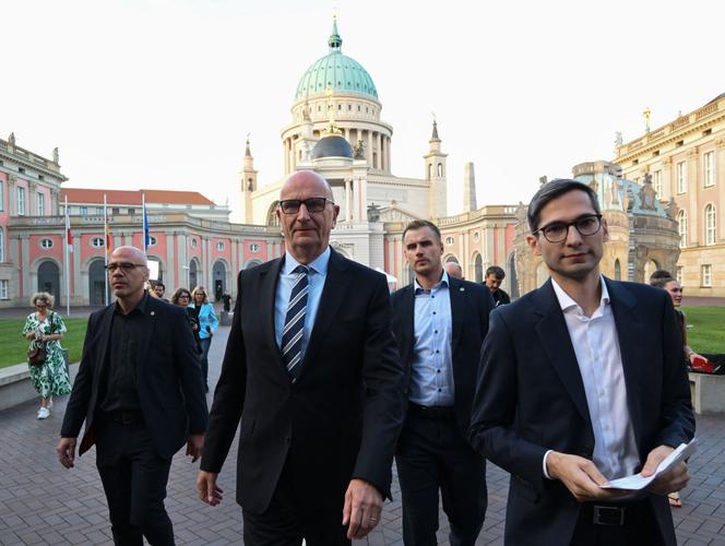 Dietmar Woidke (2e à gauche), ministre-président du Brandebourg et candidat principal du SPD aux élections régionales du Brandebourg, arrive pour une interview télévisée après la publication des sondages de sortie à Potsdam le 22 septembre 2024, lors des élections régionales dans l'État de Brandebourg, dans l'est de l'Allemagne.