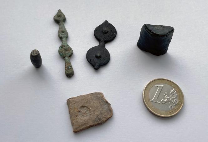 Un poinçon, deux chapelets de flans monétaires, un fragment de coin monétaire, une petite plaquette de plomb découverts à Corent, dans le Puy-de-Dôme.