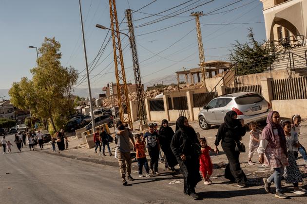 People walk toward the border near the Masnaa border crossing between Lebanon and Syria, Lebanon, September 27, 2024.