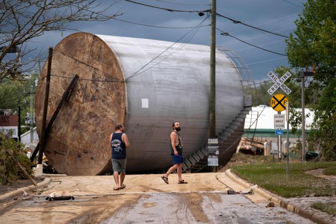 Des hommes inspectent les dégâts causés par les inondations dans le village de Biltmore à la suite de l’ouragan Hélène, le 28 septembre 2024 à Asheville, en Caroline du Nord.