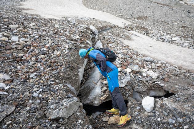 Pierre René, glaciologue, examine une fracture à la surface de la partie basse du glacier des Oulettes de Gaube, le 19 septembre 2024.