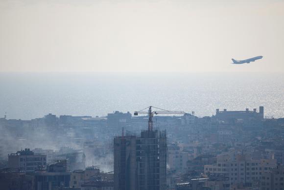 Un avion décolle alors que la fumée d’une frappe israélienne s’élève près de l’aéroport international Rafic-Hariri de Beyrouth, le 5 octobre 2024.