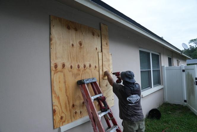 Un habitant de Palm Harbor, en Floride, cherche à protéger sa maison dans l’attente de l’ouragan Hilton, le 6 octobre 2024.
