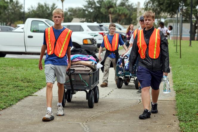 Au lycée River Ridge, des élèves aident les personnes évacuées à s’installer dans l’établissement, qui sert d’abri en prévision de l’ouragan Milton, le 7 octobre 2024, à New Port Richey, en Floride.