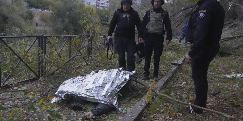 Des officiers de police inspectent le corps d’un civil, tué lors d’une attaque de bombes aériennes guidées russes qui ont endommagé des immeubles d’habitation à Kharkiv, en Ukraine, le 8 octobre 2024. 