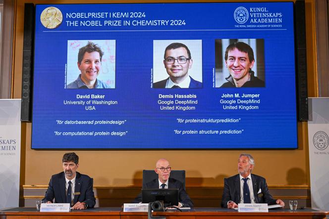 Le président du comité du prix Nobel de chimie, Heiner Linke, le secrétaire général de l’Académie royale des sciences de Suède, Hans Ellegren, et le membre du comité du prix Nobel de chimie Johan Aqvist annoncent les lauréats du prix Nobel de chimie 2024. (Sur écran, de gauche à droite) David Baker, Demis Hassabis et John Jumper, à l’Académie royale des sciences de Suède à Stockholm, en Suède, le 9 octobre 2024.