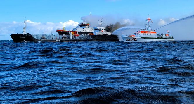 Ondas de fumaça saem do navio-tanque de bandeira alemã 'Annika' enquanto a tripulação do navio de resgate marítimo 'Arkona' lava o navio em chamas para extinguir o incêndio, no Mar Báltico, perto de Warnemuende, no nordeste da Alemanha, em 11 de outubro de 2024.