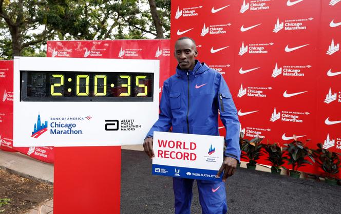 O queniano Kelvin Kiptum posa ao lado do cronômetro indicando seu recorde mundial, estabelecido em 8 de outubro de 2023, durante a Maratona de Chicago.