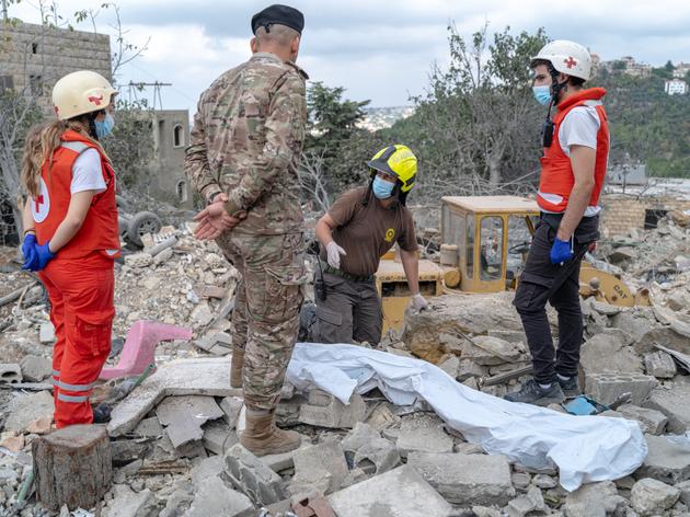 Lebanese Red Cross and civil defense teams search the rubble for body parts, at a site damaged by an Israeli air strike, in Aitou, Lebanon, October 15, 2024.