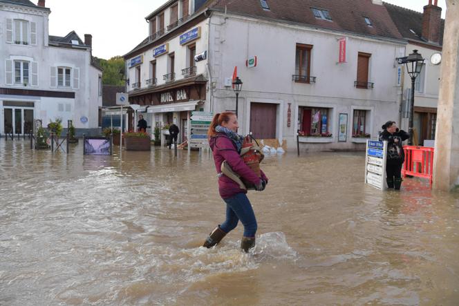 Une habitante dans une rue inondée dans le centre de Cloyes-les-Trois-Rivières (Eure-et-Loir), dans le centre de la France, le 11 octobre 2024, après le passage la tempête Kirk.