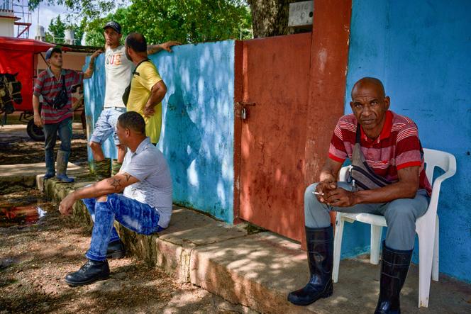 Trabalhadores esperam do lado de fora de sua fábrica em Matanzas, Cuba, em 18 de outubro de 2024, durante uma escassez geral de eletricidade.