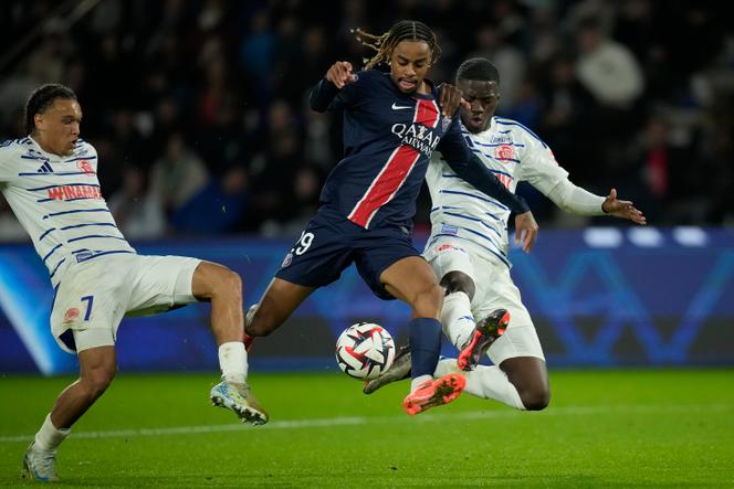 O atacante do PSG Bradley Barcola se infiltra no meio de dois jogadores do Estrasburgo, no dia 19 de outubro de 2024, no Parc des Princes, em Paris.
