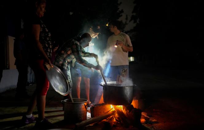Moradores preparam sopa em fogo aceso durante uma queda de energia, após a falha de uma grande usina, em Havana, Cuba, sábado, 19 de outubro de 2024.