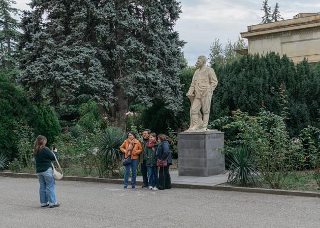Chinese tourists take a photo in front of a statue of Stalin at the museum in Gori, his birthplace. Georgia, October 24, 2024.