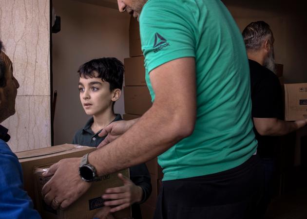 Residents of Qlayaa unload a truckload of food and hygiene products in southern Lebanon on October 23, 2024.