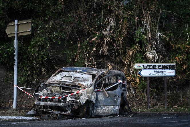 Uma pichação de “custo de vida” próximo aos destroços de um carro queimado em Lamentin, perto de Fort-de-France, 15 de outubro de 2024.