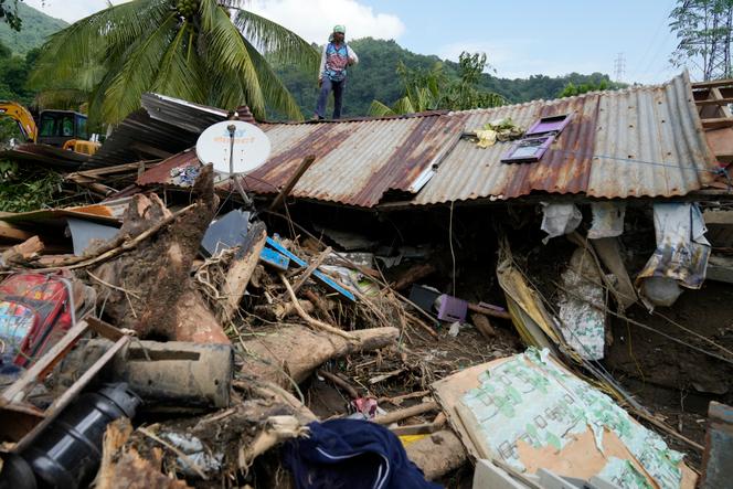 Marcelino Aringo se tient au-dessus d’une maison endommagée après un glissement de terrain déclenché par la tempête tropicale Trami qui a récemment frappé Talisay, aux Philippines, le samedi 26 octobre 2024. 