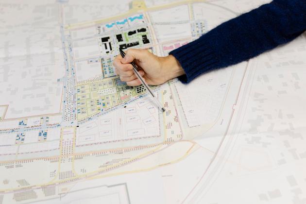 Aurélie de Domingo, gestora de projetos da Aquitanis, promotora responsável pelo ecodistrito de Bongraine, mostra um mapa do futuro distrito. Em Aytré (Charente-Maritime), 7 de outubro de 2024.