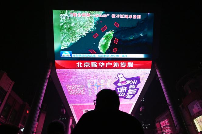 Na tela gigante de um shopping center em Pequim, um programa de notícias transmite exercícios militares chineses em torno de Taiwan, em 14 de outubro de 2024. 