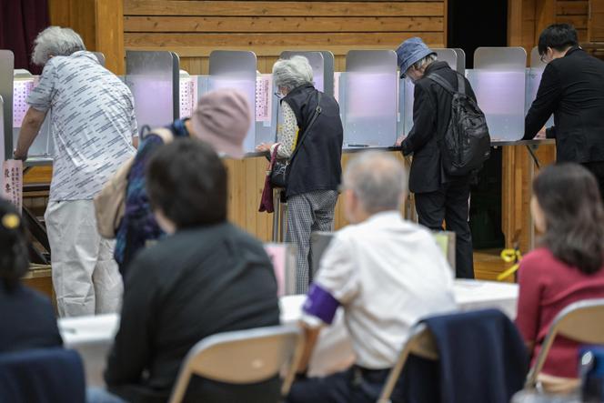 Os eleitores votam durante as eleições legislativas antecipadas, numa assembleia de voto em Tóquio, em 27 de outubro de 2024. 