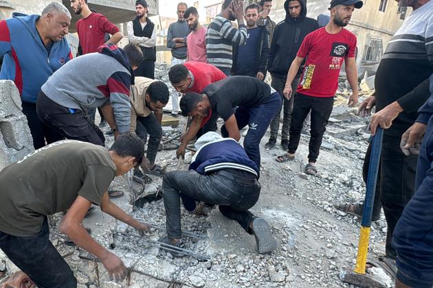 Palestinians search for survivors in the rubble after an Israeli strike, in Beit Lahiya, northern Gaza Strip, October 27, 2024.