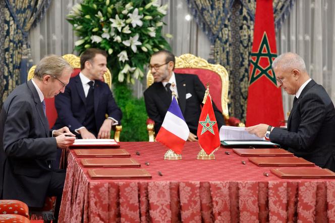 Le président français, Emmanuel Macron, et le roi du Maroc, Mohammed VI, parlent tandis que le PDG d’Alstom, Henri Poupart-Lafarge (g.), et le président de l’Office national des chemins de fer, Mohamed Rabie Khlie (d.) signent des documents, au palais royal de Rabat, le 28 octobre 2024.
