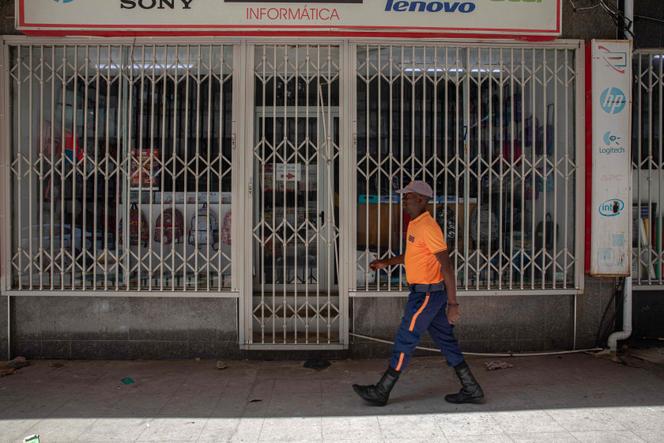 Un piéton passe devant un magasin fermé à Maputo, le 31 octobre 2024, premier jour d’une grève nationale au Mozambique en lien avec le résultat de l’élection présidentielle.