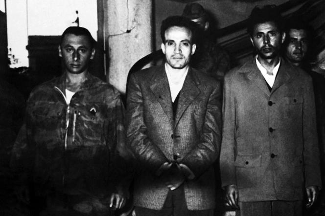 Larbi Ben M’hidi (au centre), présenté à la presse le 2 mars 1957 à Alger, quelques jours après son arrestation.