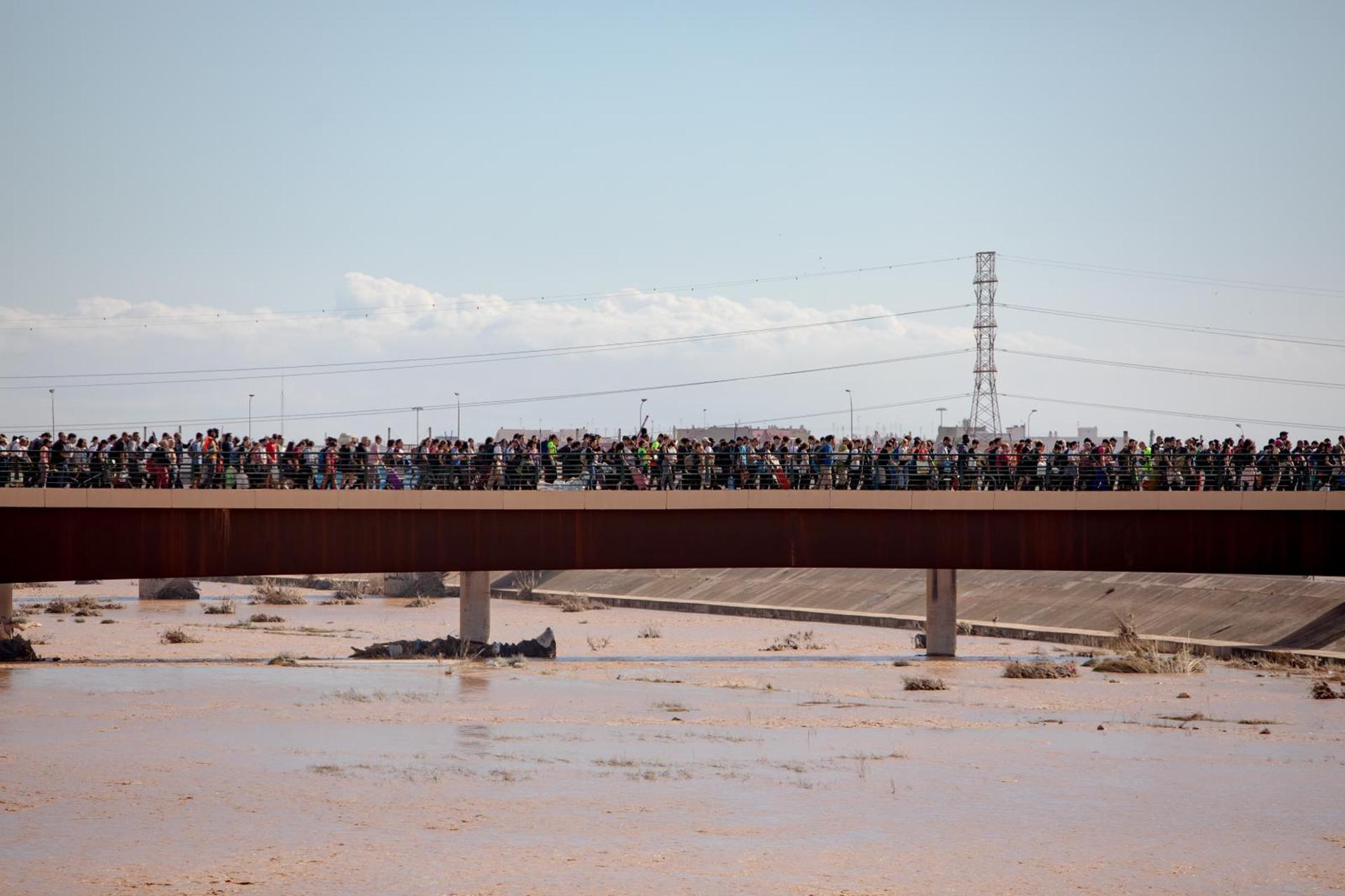 Milhares de pessoas caminham em uma das pontes que ligam a cidade de Valência às áreas afetadas pelas enchentes, 2 de novembro de 2024.