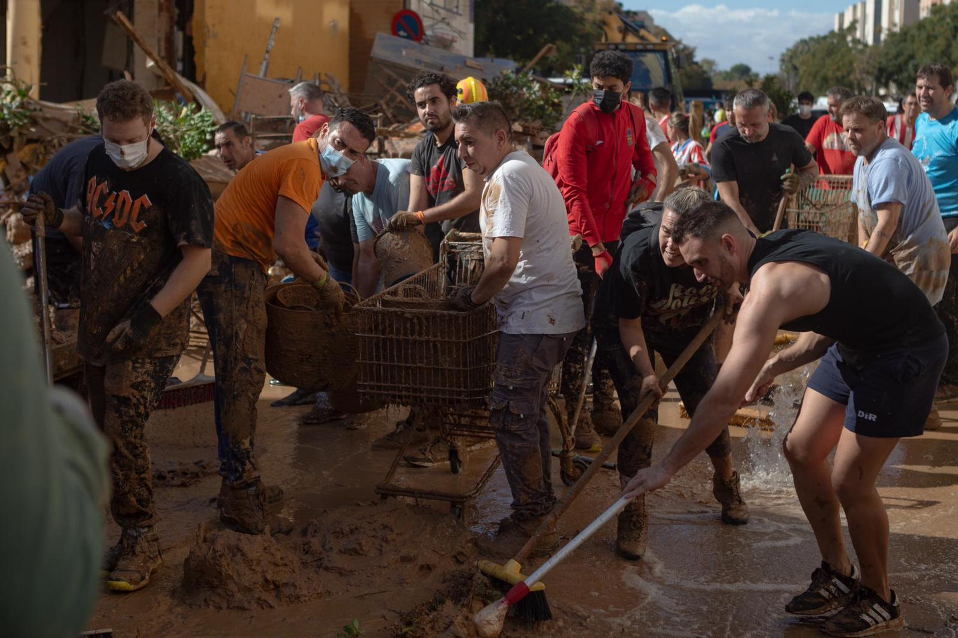 Pessoas limpam uma rua com o objetivo de reabri-la ao trânsito, em Alfafar (Espanha), 2 de novembro de 2024.