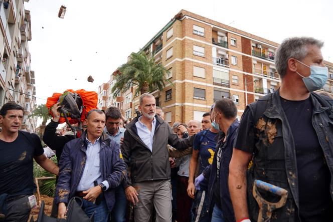 O rei Felipe VI da Espanha (centro) é questionado por moradores furiosos que jogam lama e objetos durante sua visita a Paiporta, na região de Valência, na Espanha, em 3 de novembro de 2024.