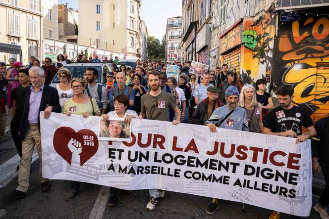 Manifestantes seguram uma faixa com os dizeres “Pela justiça e habitação digna em Marselha como noutros lugares”, em Marselha, 3 de novembro de 2024.