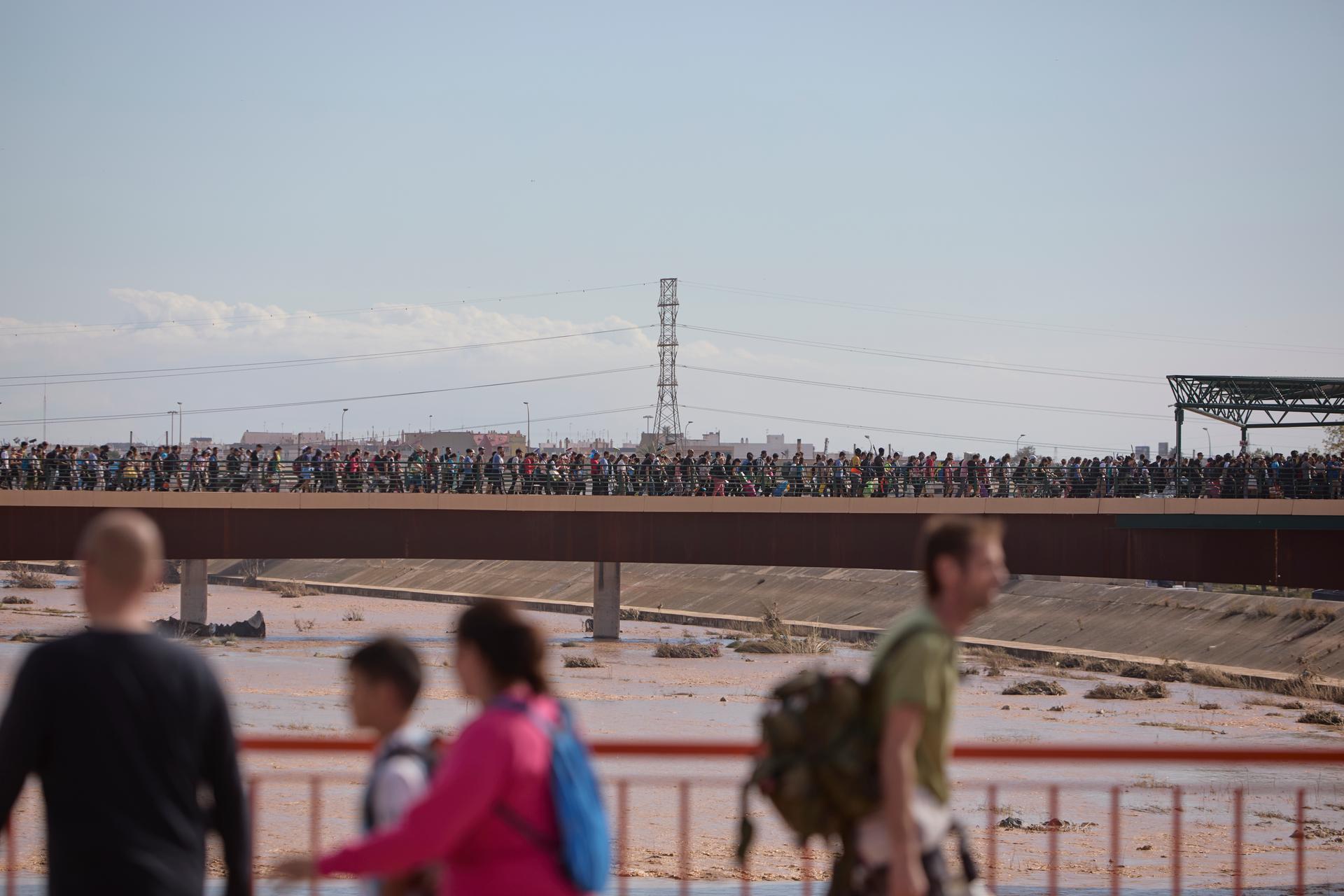 Thousands of people cross the bridge linking the city of Valencia to the affected areas on November 2, 2024.