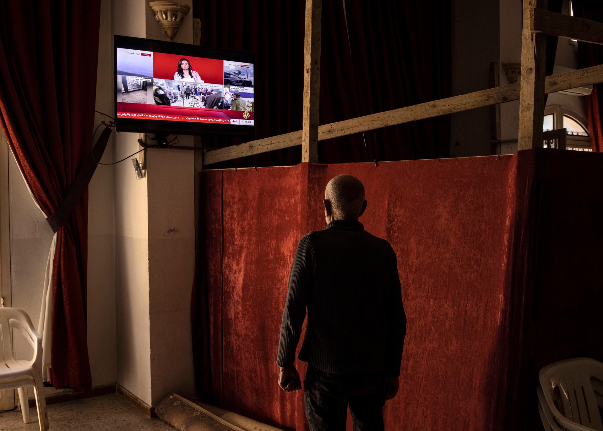 A Lebanese citizen displaced from southern Lebanon watches the news in the Druze cultural center in Bayssour, Lebanon, on October 25, 2024.