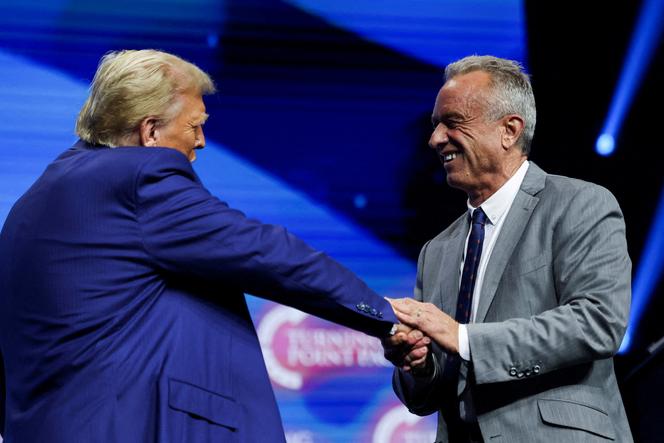Robert F. Kennedy Jr. et Donald Trump se saluent lors d'un événement de campagne parrainé par le groupe conservateur Turning Point USA, à Duluth, Géorgie, États-Unis, le 23 octobre 2024. 