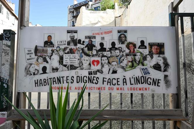 Cartaz com os retratos e nomes das oito vítimas mortas no desabamento de dois edifícios na rue d'Aubagne, em Marselha, em 17 de outubro de 2024.