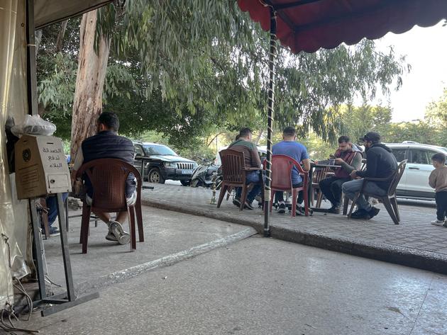 People sit in a small café in Ghobeiry, on the outskirts of Beirut's southern suburbs, after Israeli strikes on the area, November 14, 2024.