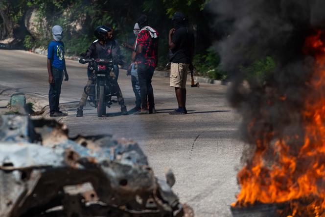 Corpos e pneus queimados em uma rua do bairro Pétion-Ville, em Porto Príncipe, 19 de novembro de 2024.