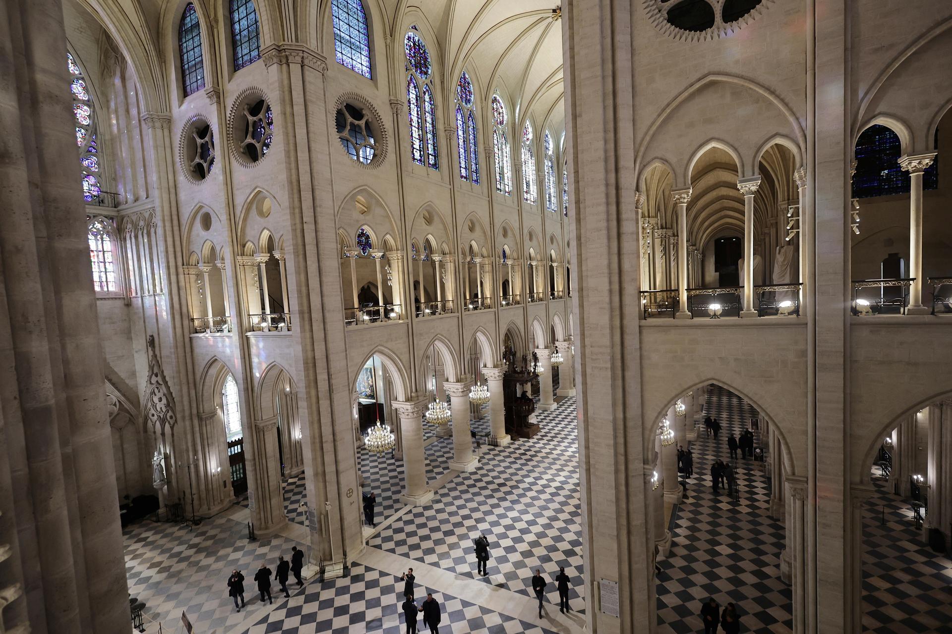 People stroll in Notre-Dame de Paris cathedral while French President Emmanuel Macron visits the restored interiors the monument, Friday, November, 29, 2024 in Paris.