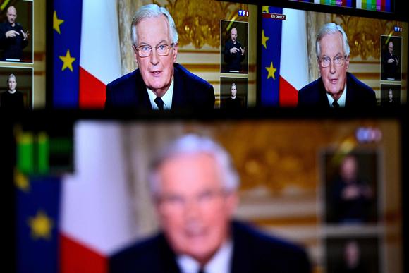 Le premier ministre, Michel Barnier, vu sur des écrans dans une salle de contrôle lors de l’interview télévisée diffusée sur TF1 et France 2, à l’hôtel Matignon, à Paris, le 3 décembre 2024.