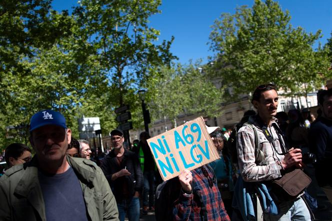 Un manifestant tient une pancarte « Ni A69 ni LGV » lors d’une manifestation contre le projet d’autoroute A69 reliant Toulouse à la ville de Castres, à Toulouse (Haute-Garonne), le 21 avril 2024. 