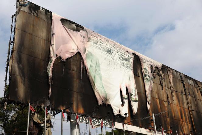 Un panneau d’affichage portant un portrait du président syrien, Bachar Al-Assad, brûlé sur la place Saadallah Al-Jabiri au centre d’Alep, le 5 décembre 2024.