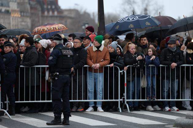 People queue at a security perimeter checkpoint.
