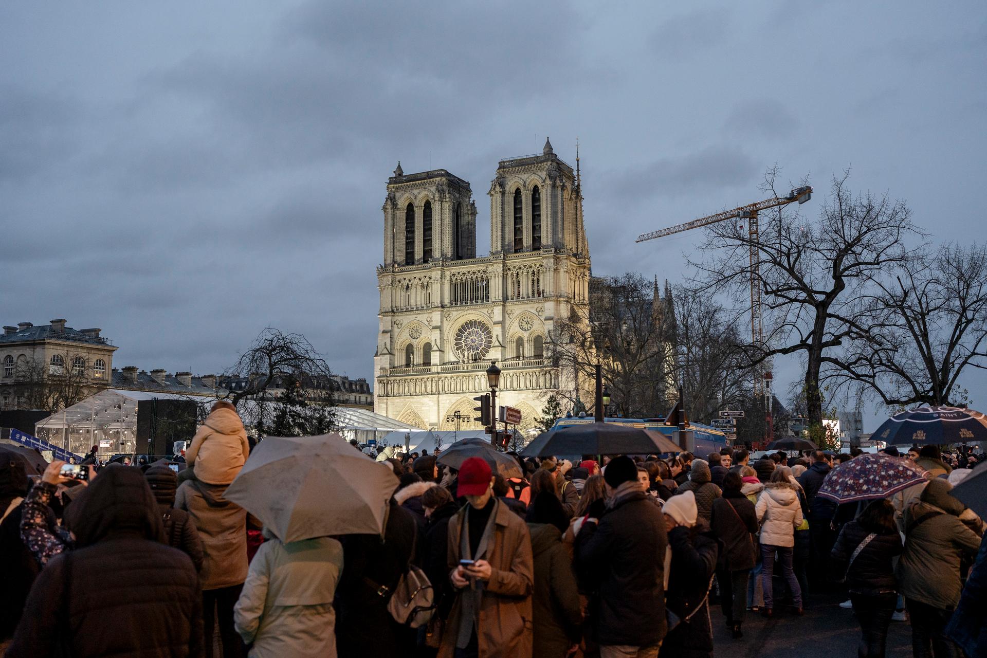 The crowd outside Notre-Dame de Paris waits to watch the ceremony on a giant screen on December 7, 2024.