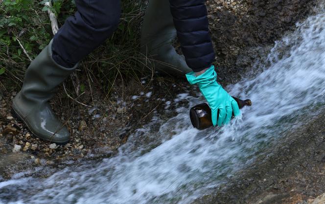 Un bénévole de l’association Générations futures prélève des échantillons d’eau sur les rejets de l’usine Solvay, qui fabrique des molécules PFAS pour l’industrie pharmaceutique et les pesticides, à Salindres, dans le sud de la France, le 18 avril 2024.